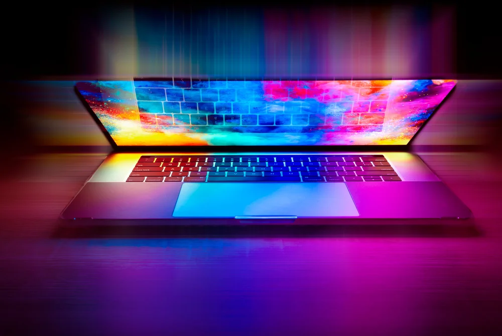 © Joshua Woroniecki / Pixabay Halbaufgeklappter Laptop leuchtet in Blau und Violett.