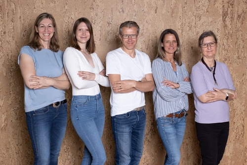 Das RKW Bayern Team - 5 Leute vor einer Holzwand